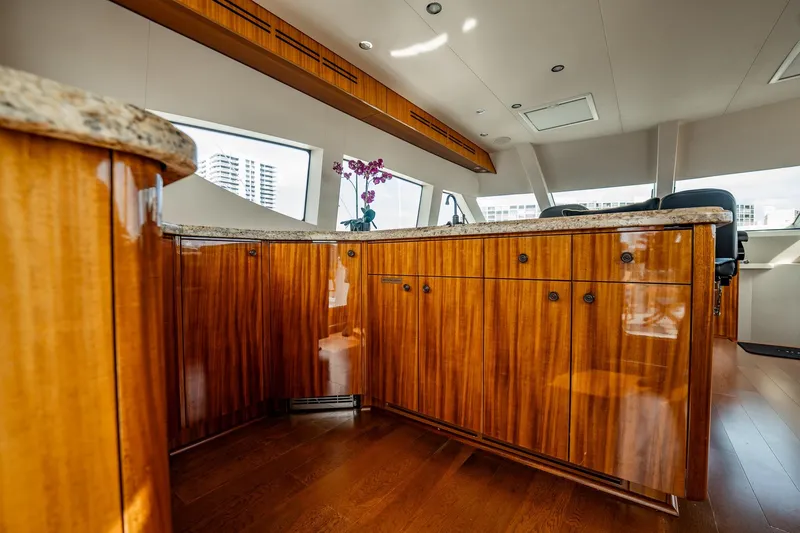Slide: The Image of Luxurious interior of 2012 Hatteras 80 Motor Yacht with polished wood cabinetry and granite countertops. - 24