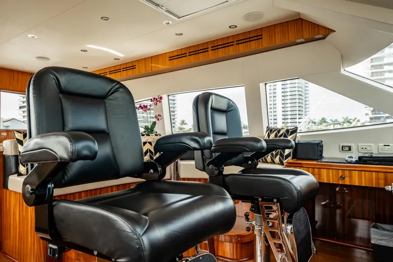 Slide: The Image of Luxurious interior of 2012 Hatteras 80 Motor Yacht with plush black captain chairs. - 32