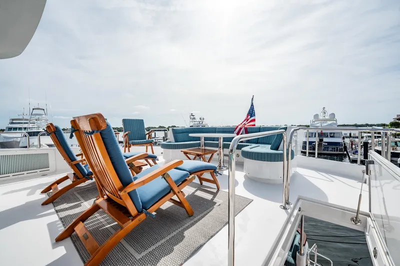 Slide: The Image of Luxurious deck of 2012 Hatteras 80 Motor Yacht with seating and American flag. - 39
