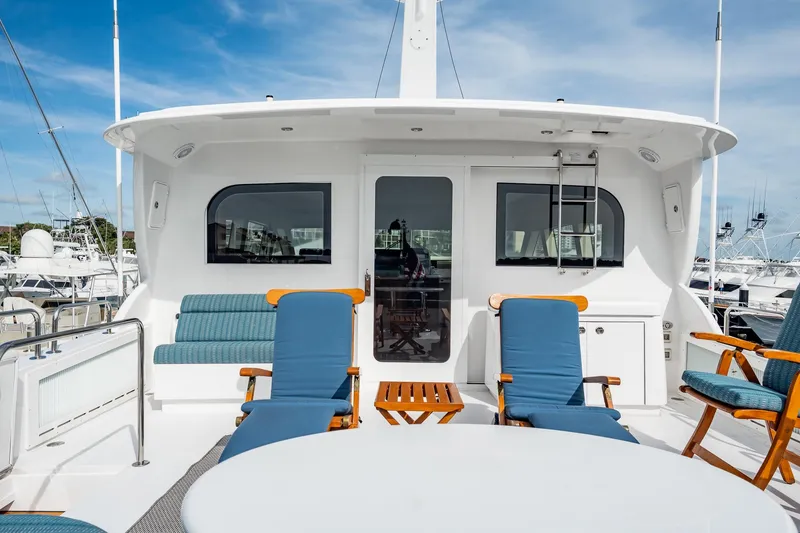 Slide: The Image of Luxurious 2012 Hatteras 80 Motor Yacht deck with seating and table, docked at marina. - 42