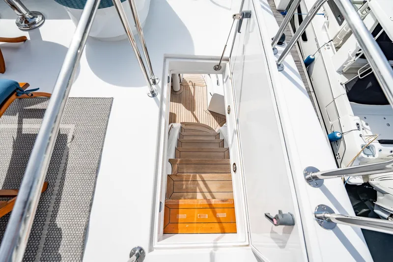 Slide: The Image of Staircase on 2012 Hatteras 80 Motor Yacht, leading to lower deck with wooden steps. - 43