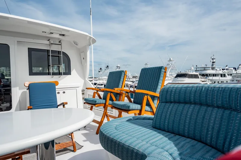 Slide: The Image of Luxurious 2012 Hatteras 80 Motor Yacht deck with blue seating and marina view. - 44