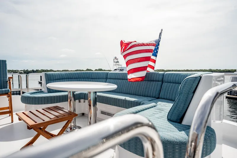 Slide: The Image of Luxurious seating area on 2012 Hatteras 80 Motor Yacht with American flag. - 48