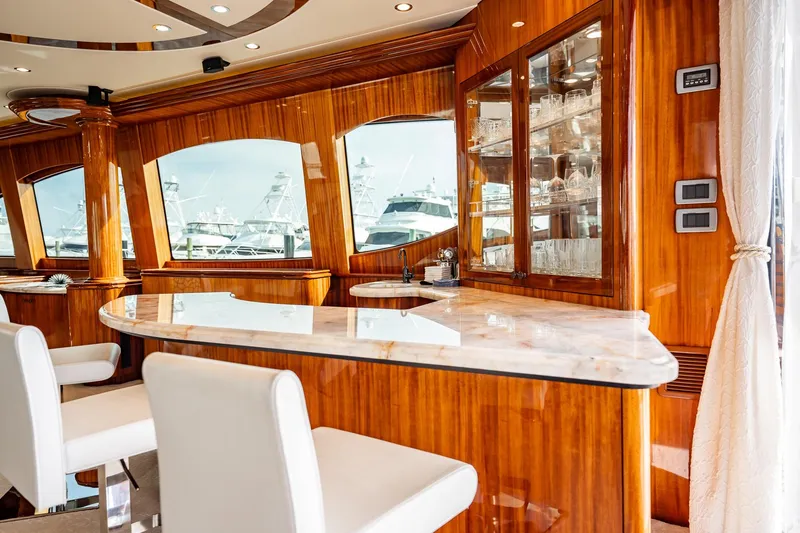 Slide: The Image of Luxurious interior of 2012 Hatteras 80 Motor Yacht with elegant wood finishes and bar area. - 50