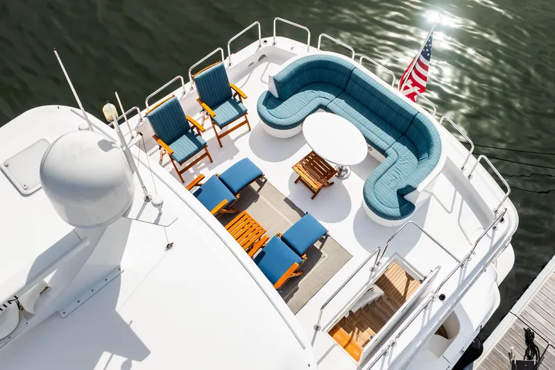 Slide: The Image of Luxurious 2012 Hatteras 80 Motor Yacht deck with seating, table, and American flag. - 6