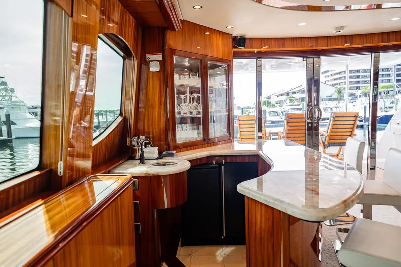 Slide: The Image of Luxurious interior of 2012 Hatteras 80 Motor Yacht with elegant bar and marina view. - 64