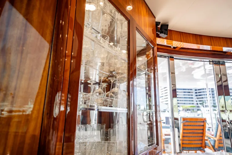Slide: The Image of Luxurious interior of 2012 Hatteras 80 Motor Yacht with elegant glassware display. - 68