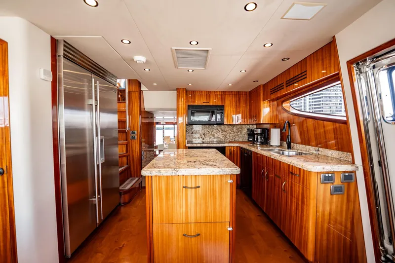 Slide: The Image of Luxurious kitchen interior of 2012 Hatteras 80 Motor Yacht with wood cabinetry and granite countertops. - 73