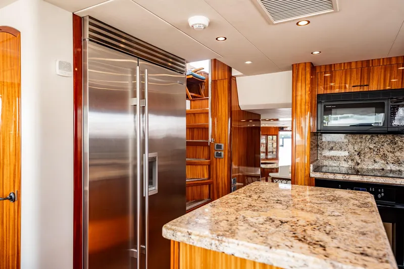 Slide: The Image of Luxurious kitchen interior of 2012 Hatteras 80 Motor Yacht with granite countertops and stainless steel appliances. - 76