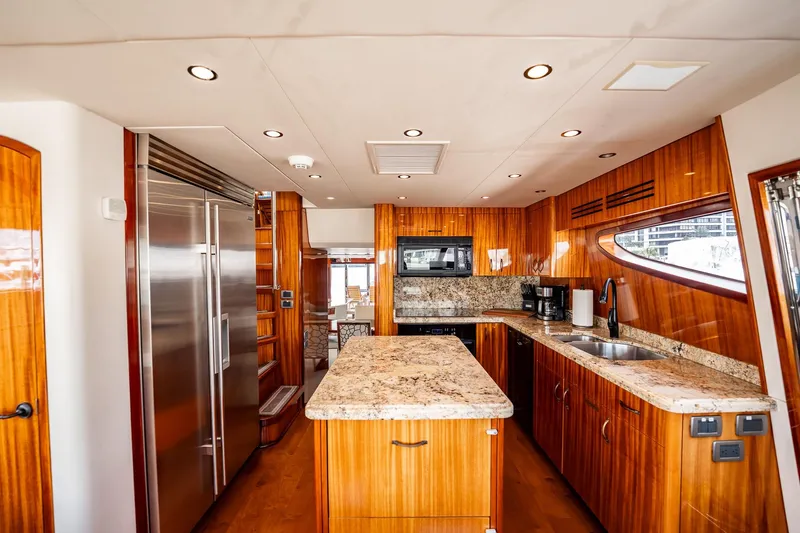 Slide: The Image of Luxurious kitchen interior of 2012 Hatteras 80 Motor Yacht with wood cabinetry and granite countertops. - 77
