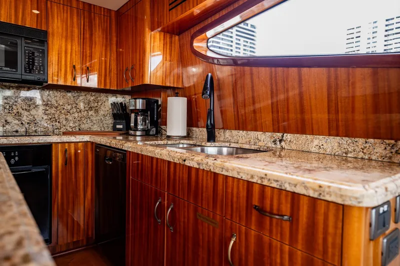 Slide: The Image of Luxurious kitchen interior of 2012 Hatteras 80 Motor Yacht with granite countertops and wood cabinetry. - 79