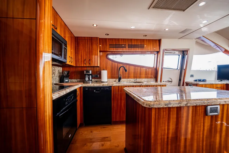 Slide: The Image of Luxurious kitchen interior of 2012 Hatteras 80 Motor Yacht with wood cabinetry and granite countertops. - 81