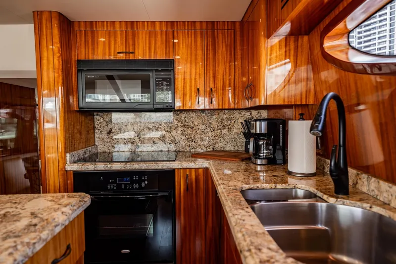 Slide: The Image of Luxurious kitchen in 2012 Hatteras 80 Motor Yacht with granite countertops and modern appliances. - 82