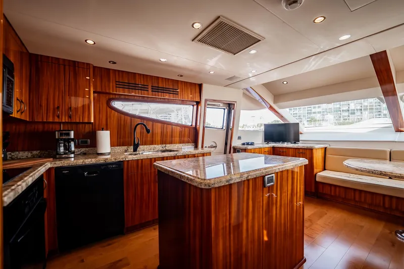 Slide: The Image of Luxurious kitchen interior of 2012 Hatteras 80 Motor Yacht with wood cabinetry and granite countertops. - 84