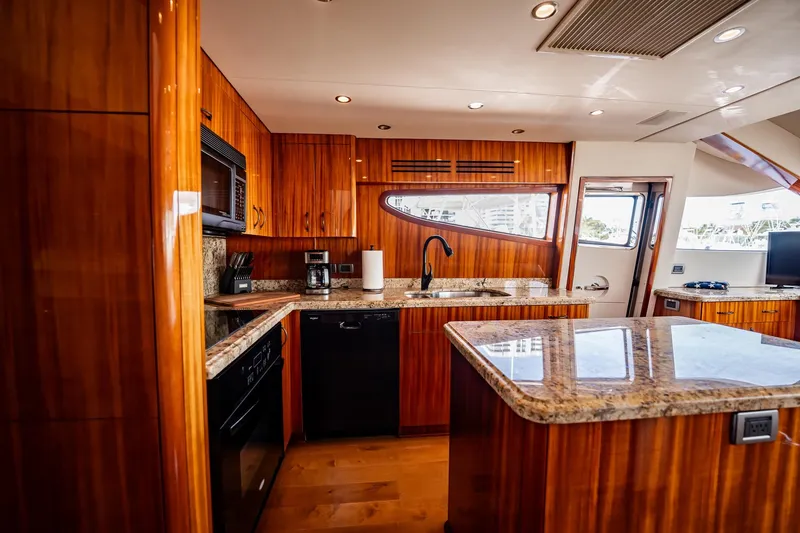 Slide: The Image of Luxurious kitchen interior of 2012 Hatteras 80 Motor Yacht with wood cabinetry and granite countertops. - 85