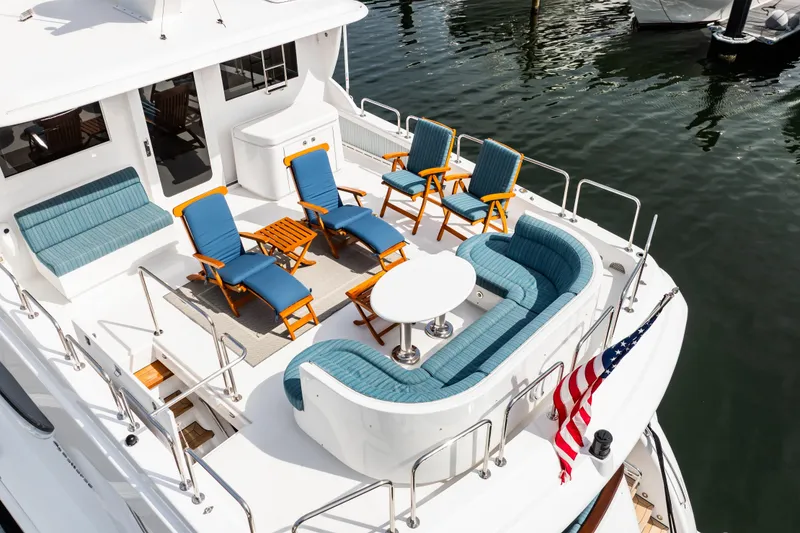 Slide: The Image of Luxurious 2012 Hatteras 80 Motor Yacht deck with elegant seating and American flag. - 9