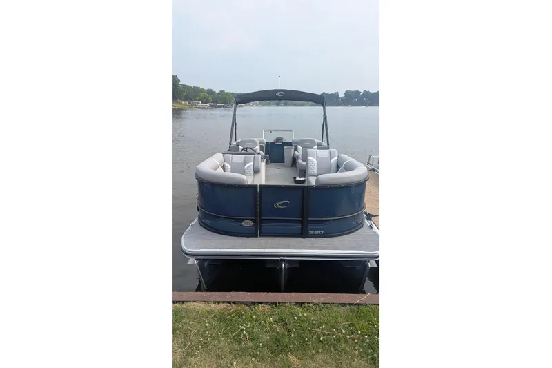 Slide: The Image of 2025 Crest CLASSIC 220 SLC pontoon boat docked on a serene lake. - 3