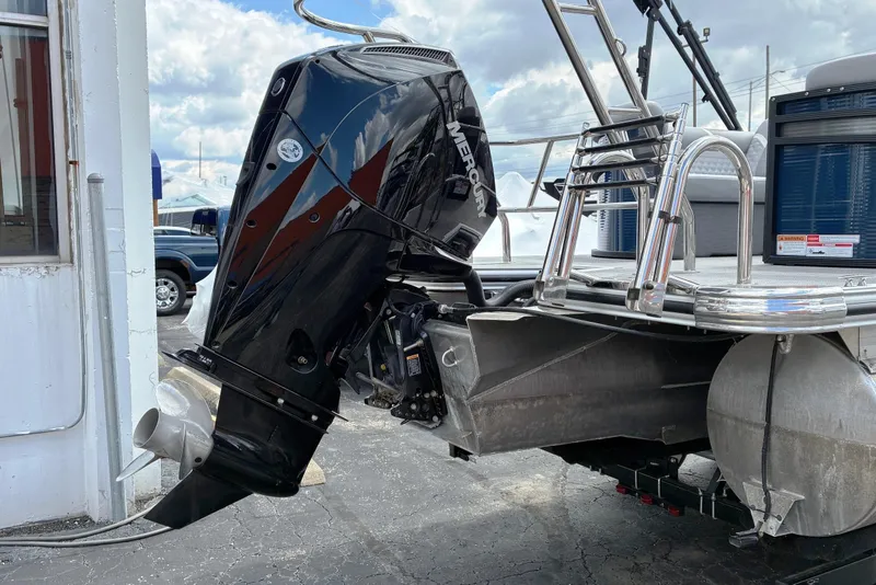 Slide: The Image of 2025 Crest CLASSIC 220 SLC boat with Mercury outboard motor, docked under cloudy skies. - 5