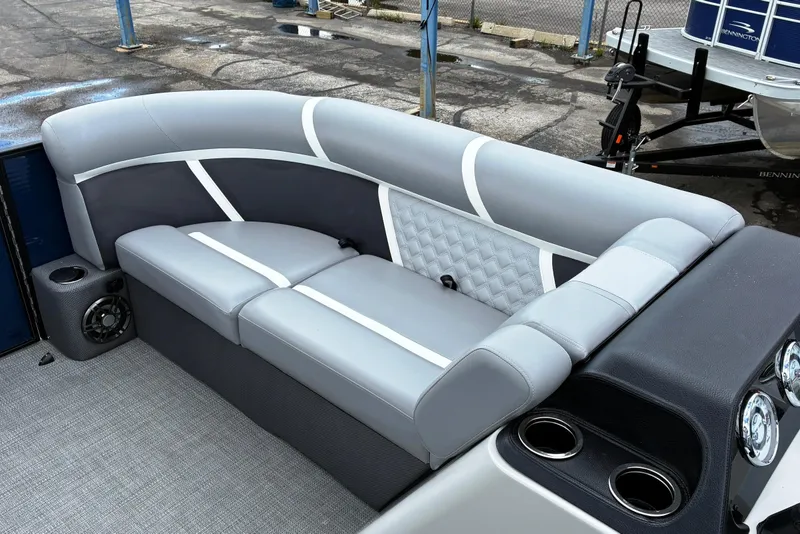 Slide: The Image of Luxurious seating on 2025 Crest CLASSIC 220 SLC pontoon boat, featuring gray upholstery and cup holders. - 8