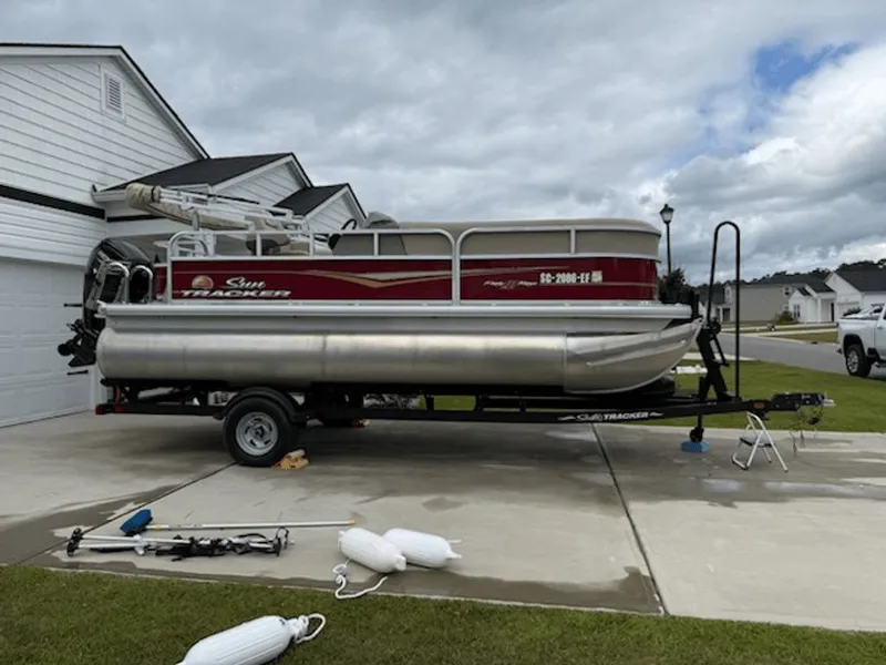The Image of 2024 Sun Tracker PARTY BARGE on trailer in driveway. - 0