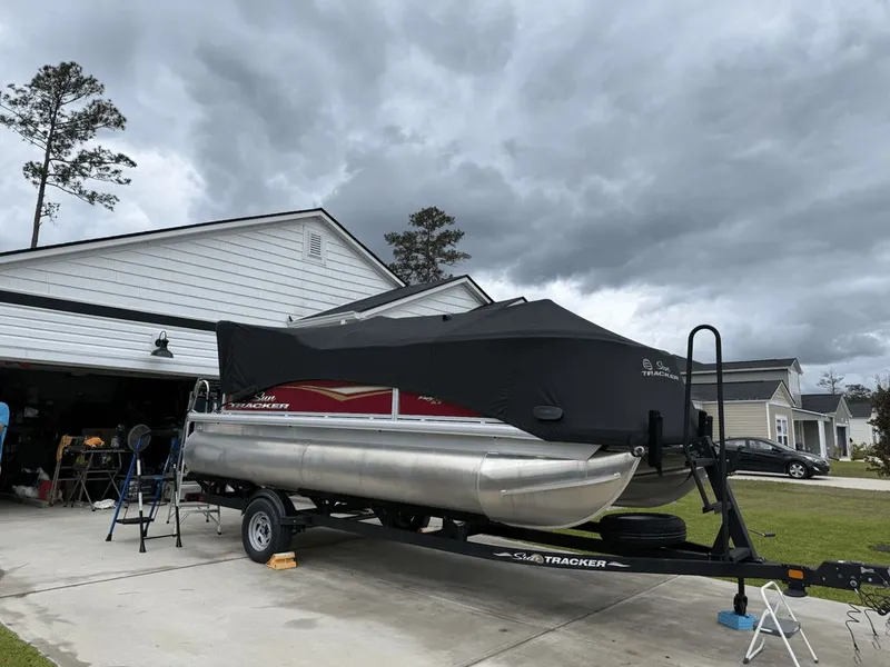 Slide: The Image of 2024 Sun Tracker PARTY BARGE on trailer in driveway. - 7
