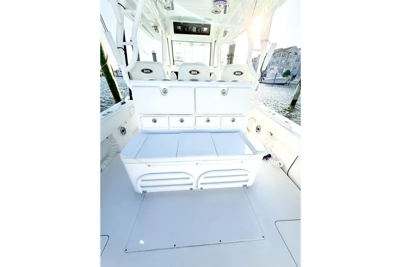 Slide: The Image of 2022 Onslow Bay 41 Tournament boat interior with seating and storage, docked by the water. - 13