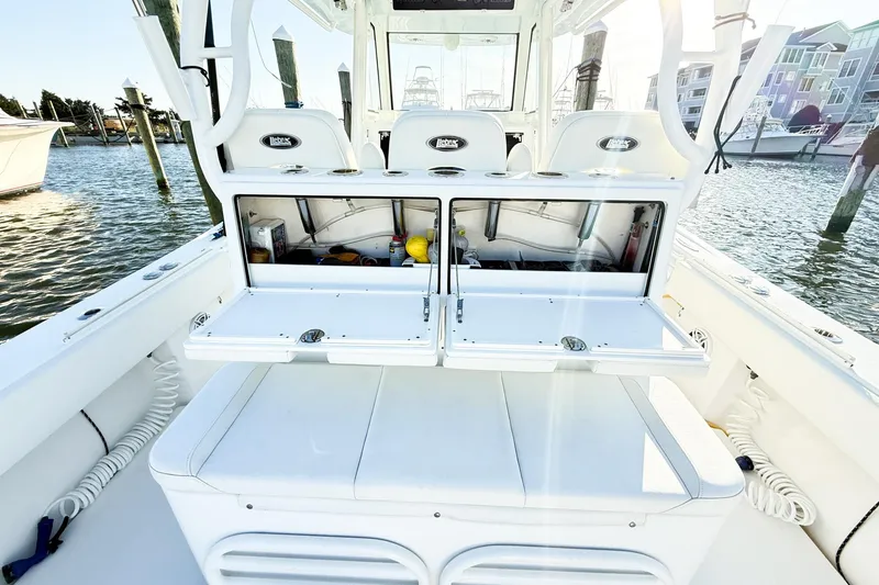 Slide: The Image of 2022 Onslow Bay 41 Tournament boat interior with open storage compartments, docked by the water. - 16
