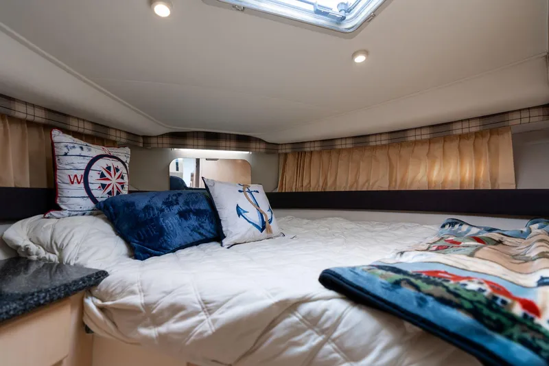 Slide: The Image of Cozy cabin interior of 2000 Carver 404 Cockpit Motor Yacht with nautical-themed pillows. - 13