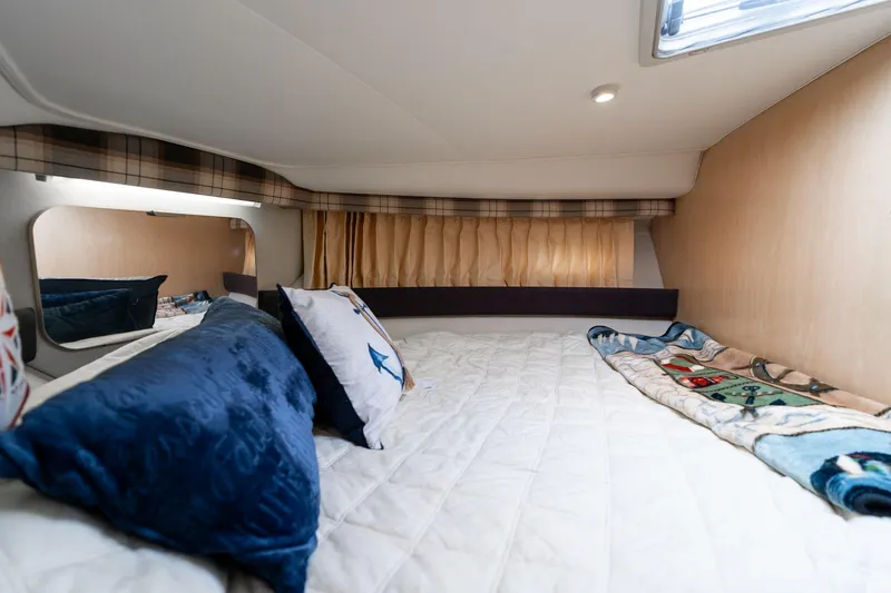 Slide: The Image of Cozy cabin interior of 2000 Carver 404 Cockpit Motor Yacht with plush bedding. - 15