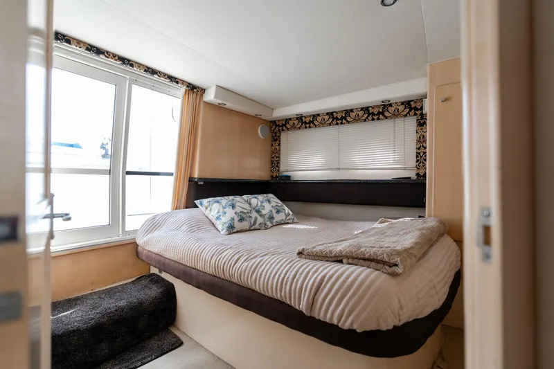 Slide: The Image of Cozy bedroom in 2000 Carver 404 Cockpit Motor Yacht with large windows and elegant decor. - 16