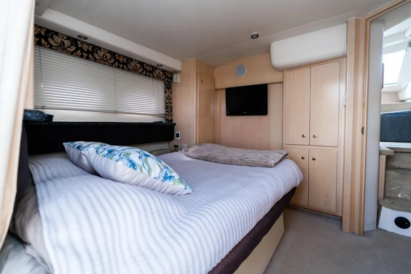 Slide: The Image of Interior of 2000 Carver 404 Cockpit Motor Yacht bedroom with bed, TV, and cabinets. - 17