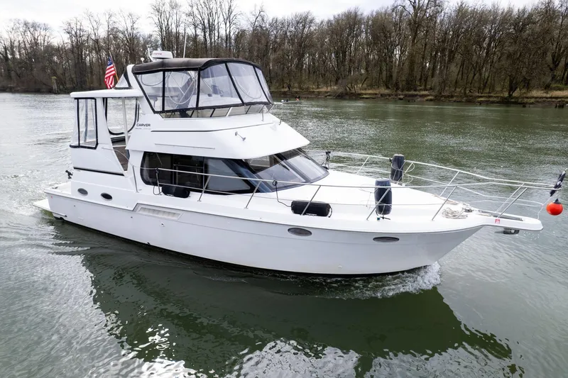 Slide: The Image of 2000 Carver 404 Cockpit Motor Yacht cruising on a calm river. - 2