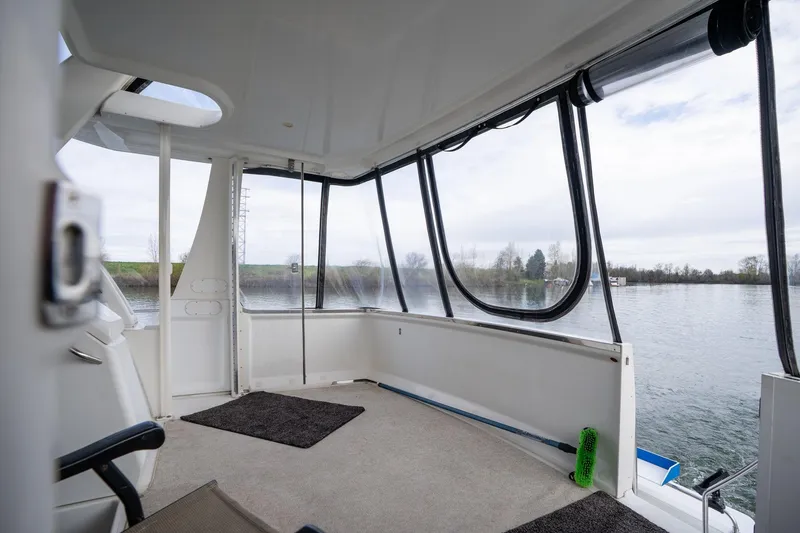 Slide: The Image of Interior view of 2000 Carver 404 Cockpit Motor Yacht with large windows and water view. - 24