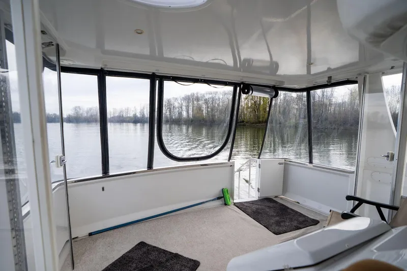 Slide: The Image of Interior view of 2000 Carver 404 Cockpit Motor Yacht overlooking serene water. - 25