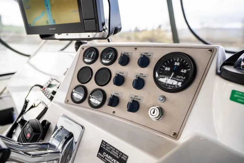 Slide: The Image of Control panel of a 2000 Carver 404 Cockpit Motor Yacht with gauges and switches. - 28