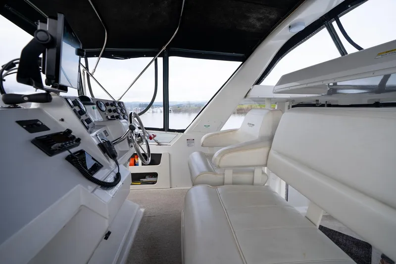 Slide: The Image of Interior of 2000 Carver 404 Cockpit Motor Yacht with steering wheel and seating. - 29