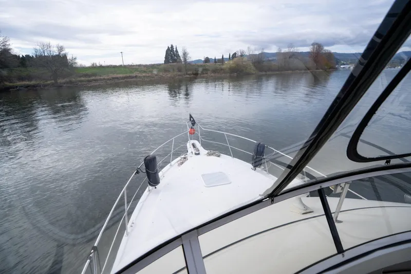 Slide: The Image of Front view from a 2000 Carver 404 Cockpit Motor Yacht on a calm river. - 31