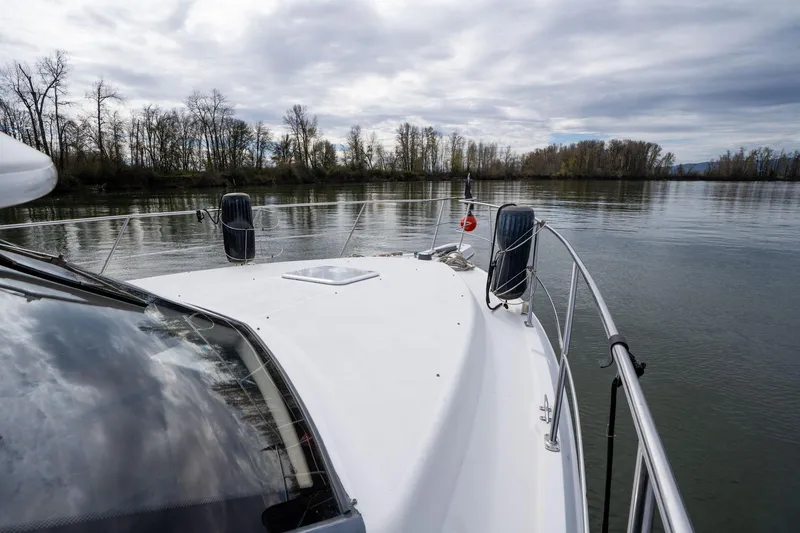 Slide: The Image of 2000 Carver 404 Cockpit Motor Yacht on calm river with cloudy sky. - 32