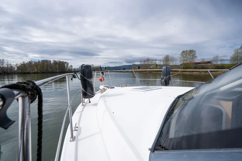 Slide: The Image of 2000 Carver 404 Cockpit Motor Yacht cruising on a calm river under cloudy skies. - 34