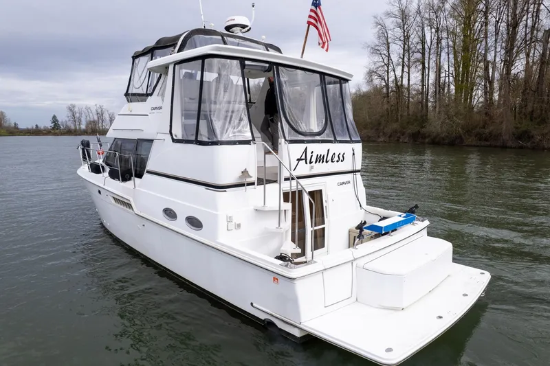 Slide: The Image of 2000 Carver 404 Cockpit Motor Yacht on calm river with trees in background. - 36