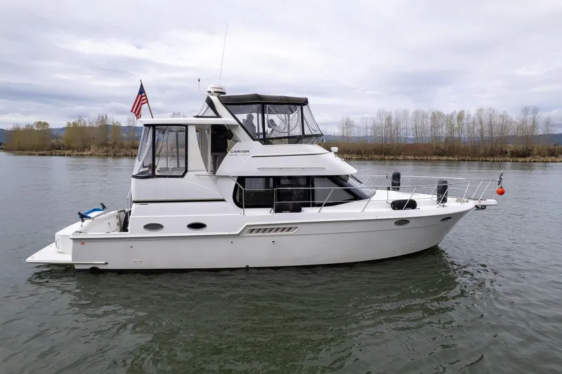 Slide: The Image of 2000 Carver 404 Cockpit Motor Yacht on calm water, side view. - 37