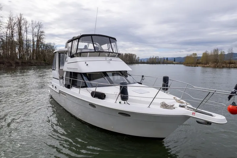 Slide: The Image of 2000 Carver 404 Cockpit Motor Yacht cruising on a serene river. - 38