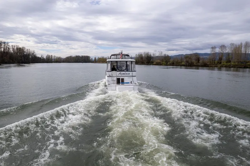 Slide: The Image of Carver 404 Cockpit Motor Yacht cruising on a serene river, 2000 model. - 45