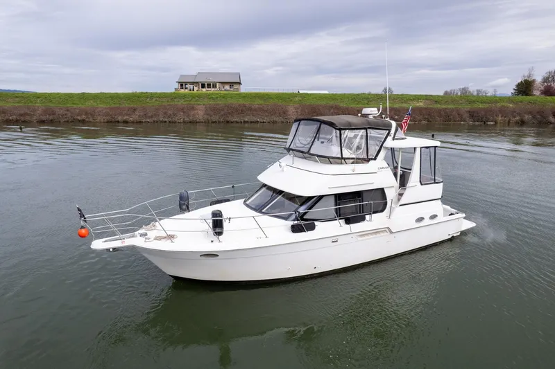 Slide: The Image of 2000 Carver 404 Cockpit Motor Yacht cruising on calm water. - 47