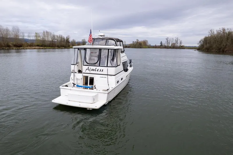 Slide: The Image of 2000 Carver 404 Cockpit Motor Yacht on a calm river, overcast sky. - 48