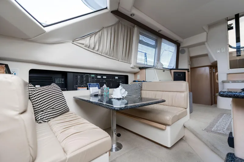 Slide: The Image of Interior of 2000 Carver 404 Cockpit Motor Yacht with beige seating and dining area. - 6