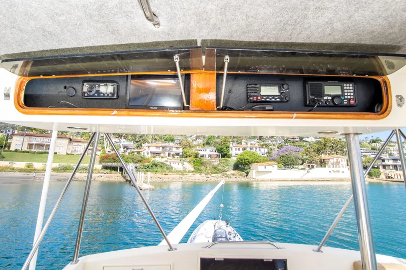 Slide: The Image of 1986 Ocean Yachts 48 Super Sport cockpit with navigation equipment, overlooking coastal homes and blue water. - 13