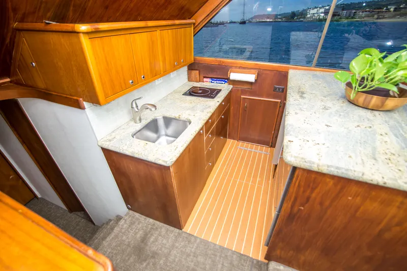Slide: The Image of 1986 Ocean Yachts 48 Super Sport galley with wood cabinetry and ocean view. - 23