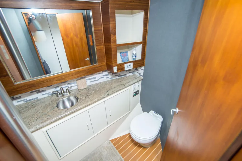 Slide: The Image of Luxurious bathroom in 1986 Ocean Yachts 48 Super Sport, featuring modern fixtures and wood accents. - 28