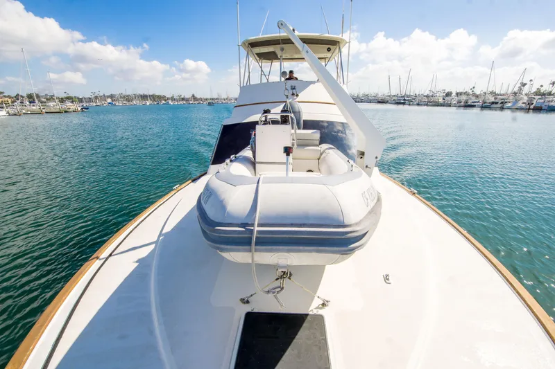 Slide: The Image of 1986 Ocean Yachts 48 Super Sport on water, featuring a dinghy on deck. - 6